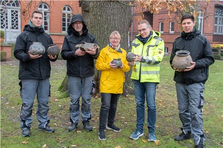 Viacheslav Hladkyi (v. l.), Johann Arends, Claudia Neutzer, Dr. Jan F. Kegler und Taras Khromushyn zeigen die ungewöhnlich gut erhaltenen Kugeltöpfe aus dem Spätmittelalter und einen Pferdeschädel, die bei den Grabungen auf der Japaninsel gefunden wurden.