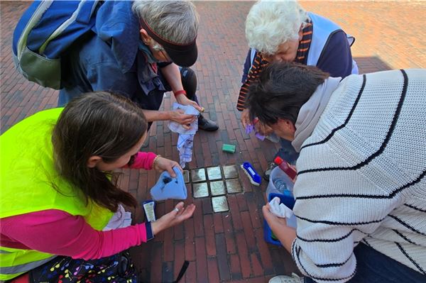 Vier Frauen ehren Familie Schönthal aus der Sielstraße, deren Stolpersteine sie auf Hochglanz polieren. Foto: Silvia Cornelius