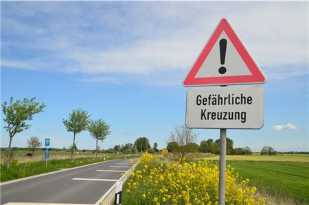 Warnschilder weisen auf die gefährliche Kreuzung hin.