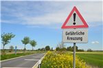 Warnschilder weisen auf die gefährliche Kreuzung hin.
