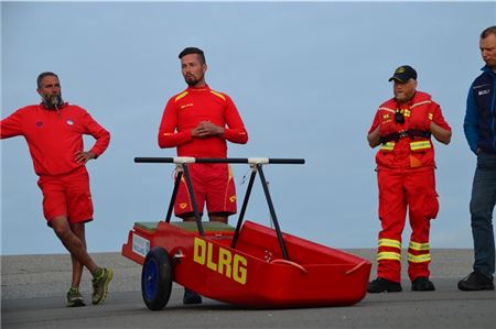 Yasha Kube (Mitte), Einsatzleiter der DLRG Varel, erklärte die Geschichte und Funktionsweise des Schlickschlittens.