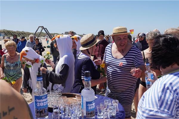 Trend und Tradition: Anbaden auf Baltrum lockt Hunderte Schaulustige an den Badestrand Zum Aufwärmen gab es hinterher einen Klaren und vom Bürgermeister eine Rose zum Dank.